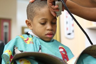 Una peluquería paga a los niños que leen mientras les cortan el pelo